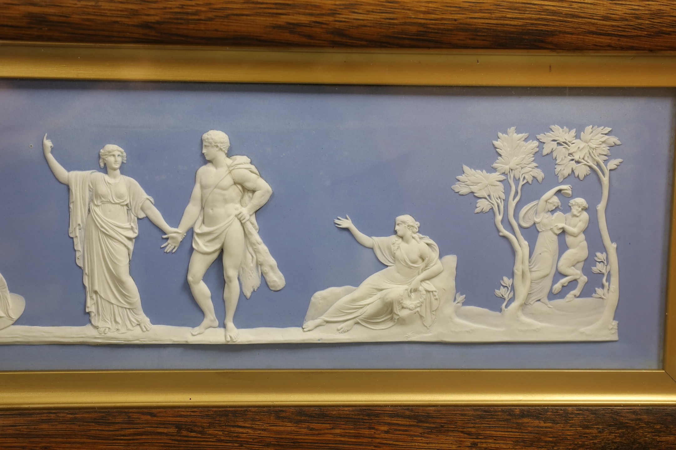 A large Wedgwood blue jasper plaque, early 20th century, impressed mark Wedgwood England, plaque 44 cm X 14 cm, framed and glazed